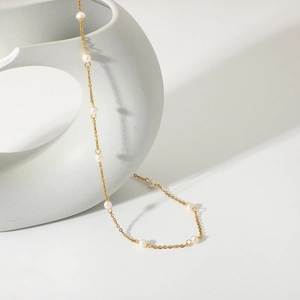 Detail of 18K gold-plated stainless steel chain necklace with small white pearls