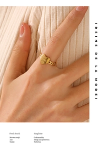 Detail of a 18K gold heart-shaped ring with Love engraving and chain band on a model