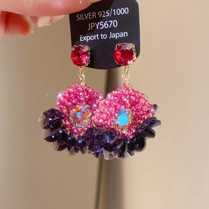 Detail of bohemian drop earrings with 925 silver tag and vibrant zircon crystals