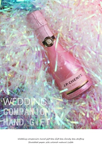 Iridescent shredded paper filler surrounding a mini pink sparkling wine bottle for gifts