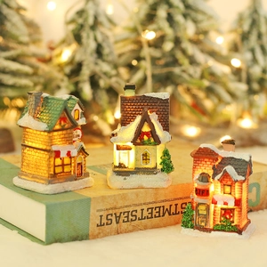 Dreiteiliges Set leuchtender Weihnachtshäuser mit Schneedetails und warmen LED-Lichtern