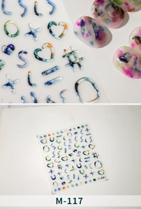 Macro detail of M-117 nail stickers with colorful alphabet and heart symbols