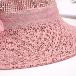 Dettaglio del cappello di paglia rosa con trama a maglia fine e nastro di raso decorativo