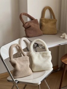 Plush faux fur tote bags in brown, yellow, and beige displayed on a chair and desk