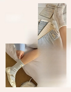 Close-up of blue polka dot crew socks with delicate cream bows and ruffled lace edges
