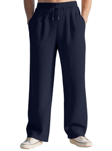 Detail of navy blue pleated fabric texture and elastic drawstring waistband on trousers