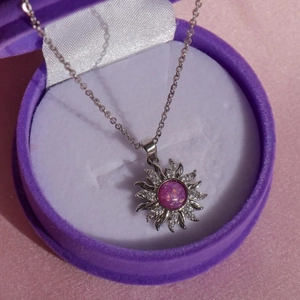 Silberne Sonnenstrahl-Halskette mit rosa Opal-Anhänger in violetter Schmuckschachtel