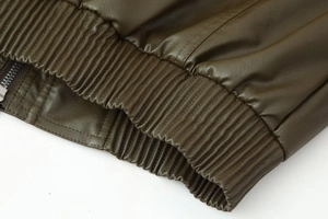 Detail macro view of dark olive faux leather jacket with ribbed cuffs and hem textures