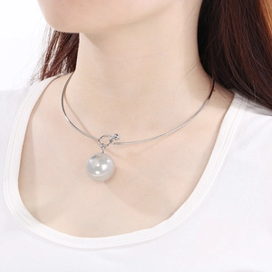 Détail du ras-du-cou en acier inoxydable argenté avec pendentif perle blanche sur modèle