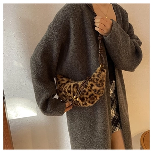 Détail du sac croissant en peluche léopard avec bandoulière en cuir et décor doré