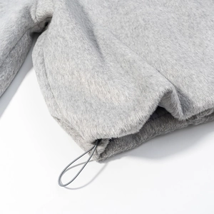 Détail macro du tissu polaire gris clair épais et cordon de serrage réglable à l'ourlet