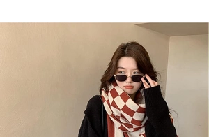 Detail shot of a fashion model wearing red and white checkered knit scarf and sunglasses