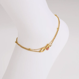 Double-layered gold anklet featuring infinity symbol and red evil eye bead on a model