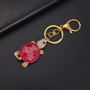 Detail showing the pink rhinestone turtle shell and golden lobster clasp on the keychain
