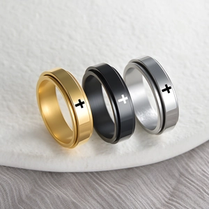 Rotating stainless steel rings in gold, black and silver featuring laser cross pattern