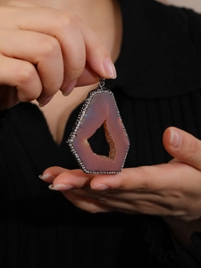 Close-up of natural purple druzy agate pendant with silver diamond-encrusted border