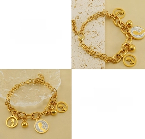 Detailed macro view of 18K gold double layer stainless steel bracelet with portrait charms