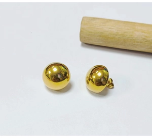 Detailed view of polished 18K gold bean stud earrings with butterfly backings
