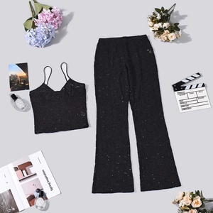 Conjunto de encaje negro con top corto y pantalones acampanados con accesorios de moda