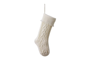 Detail of cream knitted Christmas stocking with heart texture and delicate lace trim