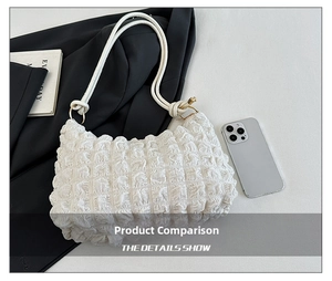 Detail showing white pleated bubble fabric texture and gold ring hardware on handbag