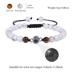 Gevlochten armband met tijgeroog, witte howliet en centrale projectiesteen