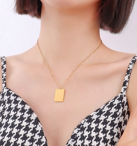 Detailed close-up of a square checkered pendant necklace in 18k gold-plated titanium steel