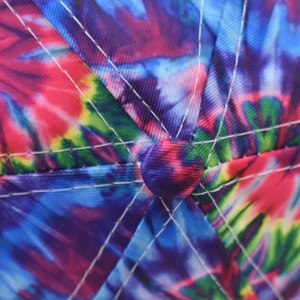 Macro shot of colorful tie-dye baseball cap featuring white stitching and top button detail
