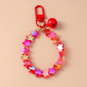 Close-up of star-shaped beads, red bell and metal clasp of the colorful keychain