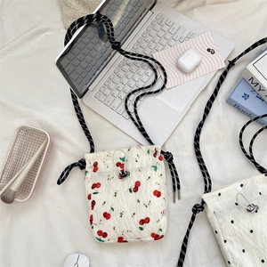 Flat lay of small floral canvas crossbody bags with cherry and polka dot prints