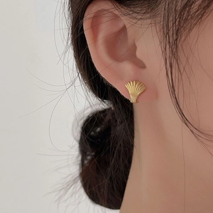 Orecchino a conchiglia minimalista in argento 925 dorato indossato da una modella