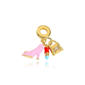Detailed view of gold charms featuring a pink heel, lipstick, and diamond handbag pendant
