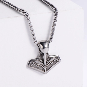 Detail of Viking Mjolnir pendant with bird totem relief and square pearl chain necklace