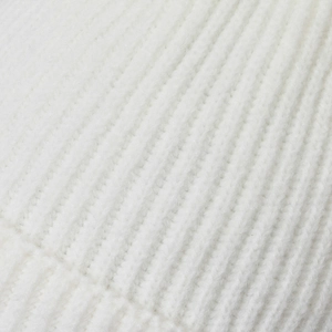 Close-up of white knitted beanie featuring warm vertical ribbed texture for winter