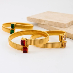 Gouden roestvrijstalen open armband met gekleurde zirkoonstenen op stenen sokkel