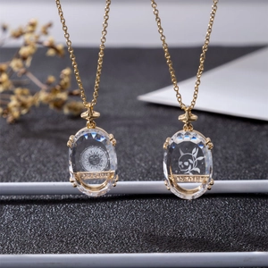 Close-up of gold 18K plated Tarot pendants featuring The Sun and Death crystal designs