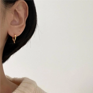 Minimalist twisted golden silver hoop earrings shown on model for daily commuting style