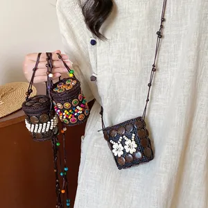 Detail of bohemian handmade woven coconut shell mini bags with floral bead embellishments