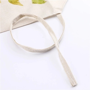 Detailed close-up of durable cream-colored cotton linen fabric and reinforced handle stitching