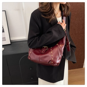 Detail der Vintage-Hobo-Tasche aus bordeauxrotem Leder mit goldenen Nieten am Modell