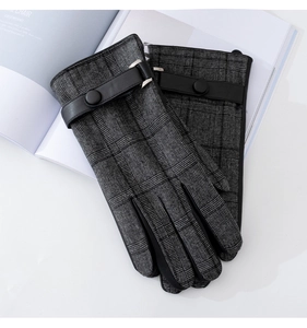 Detail of grey and black plaid wool gloves with leather strap and button accent