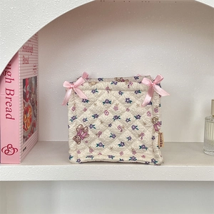 Quilted fabric storage basket with cartoon bear print and pink ribbon bows for desk