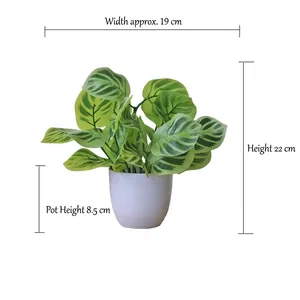 Detail view of artificial green leaves with realistic textures and white plastic flower pot