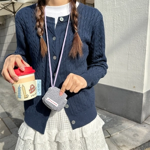 Close-up of a plush gray mini headphone pouch with a light purple neck strap on a model
