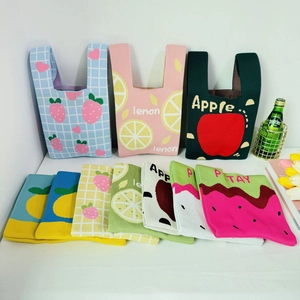 Colorful fruit-themed knitted tote bags in lemon, apple, and strawberry designs