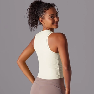 Détail des coutures froncées sur un débardeur de yoga ajusté de couleur blanc crème
