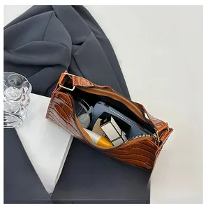 Detail of brown crocodile pattern patent leather bag showing interior storage capacity
