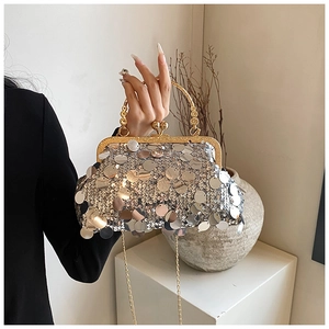 Close-up of a silver sequin evening bag with gold metal frame and chain strap detail