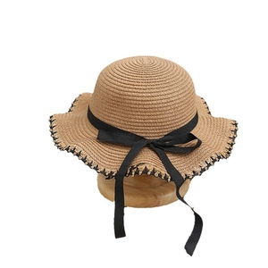 Straw sun hat for children with black ribbon bow and wavy wide brim for outdoor shade