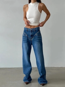 Detail showing the unique V-shaped waist design and stitching on blue wide-leg jeans
